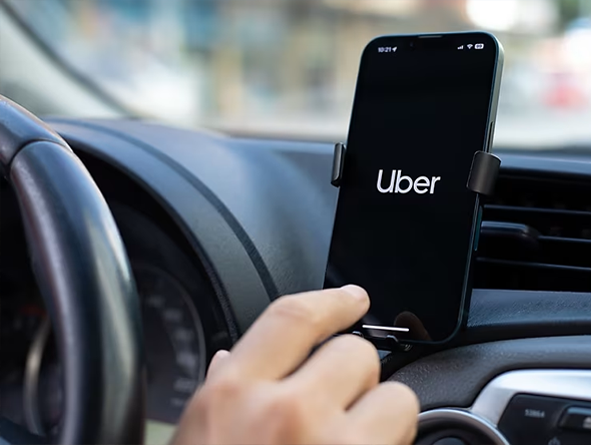 passenger in car holding smartphone that reads rideshare on the screen